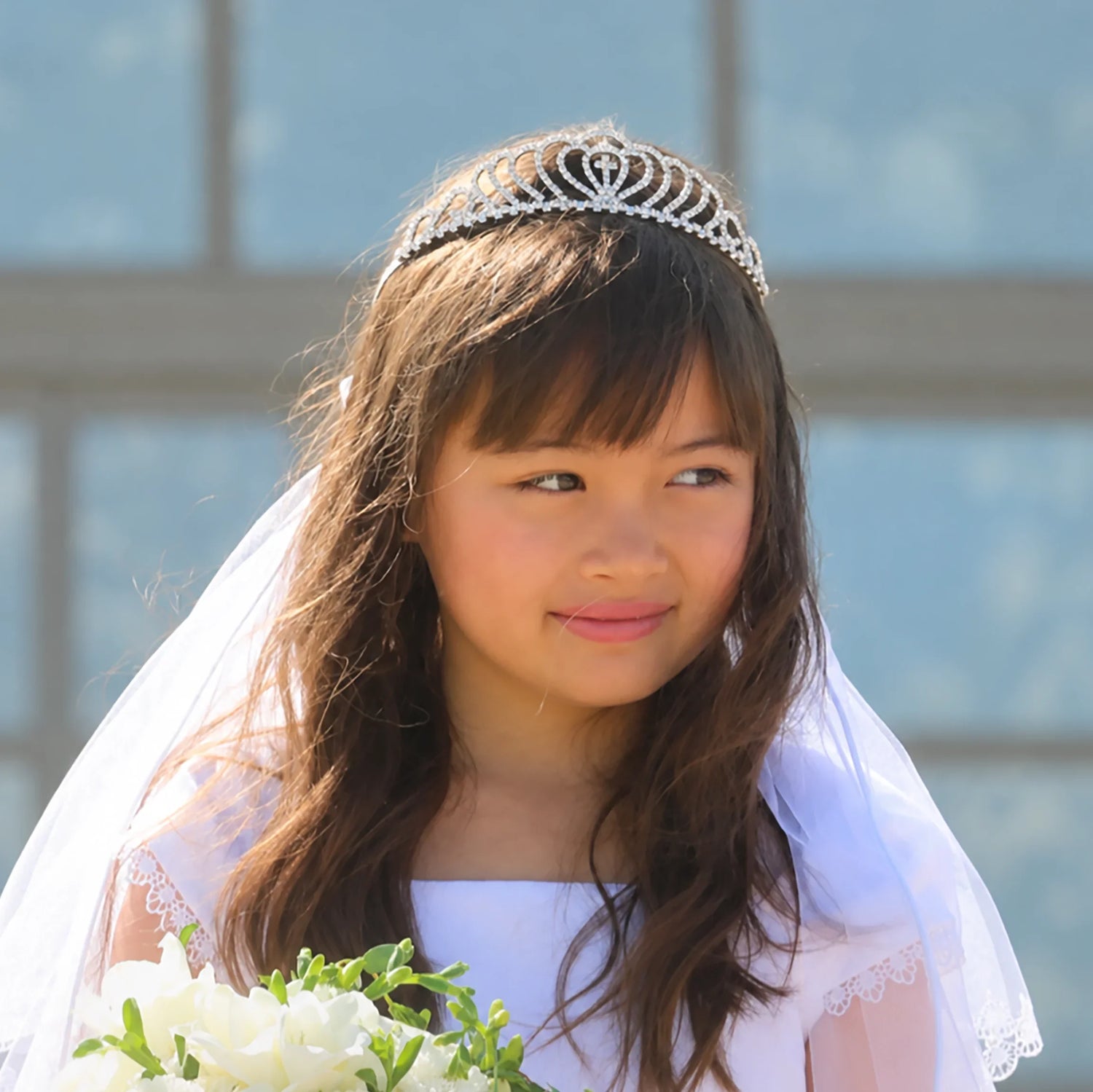 Girl wearing a white communion veil and silver tiara