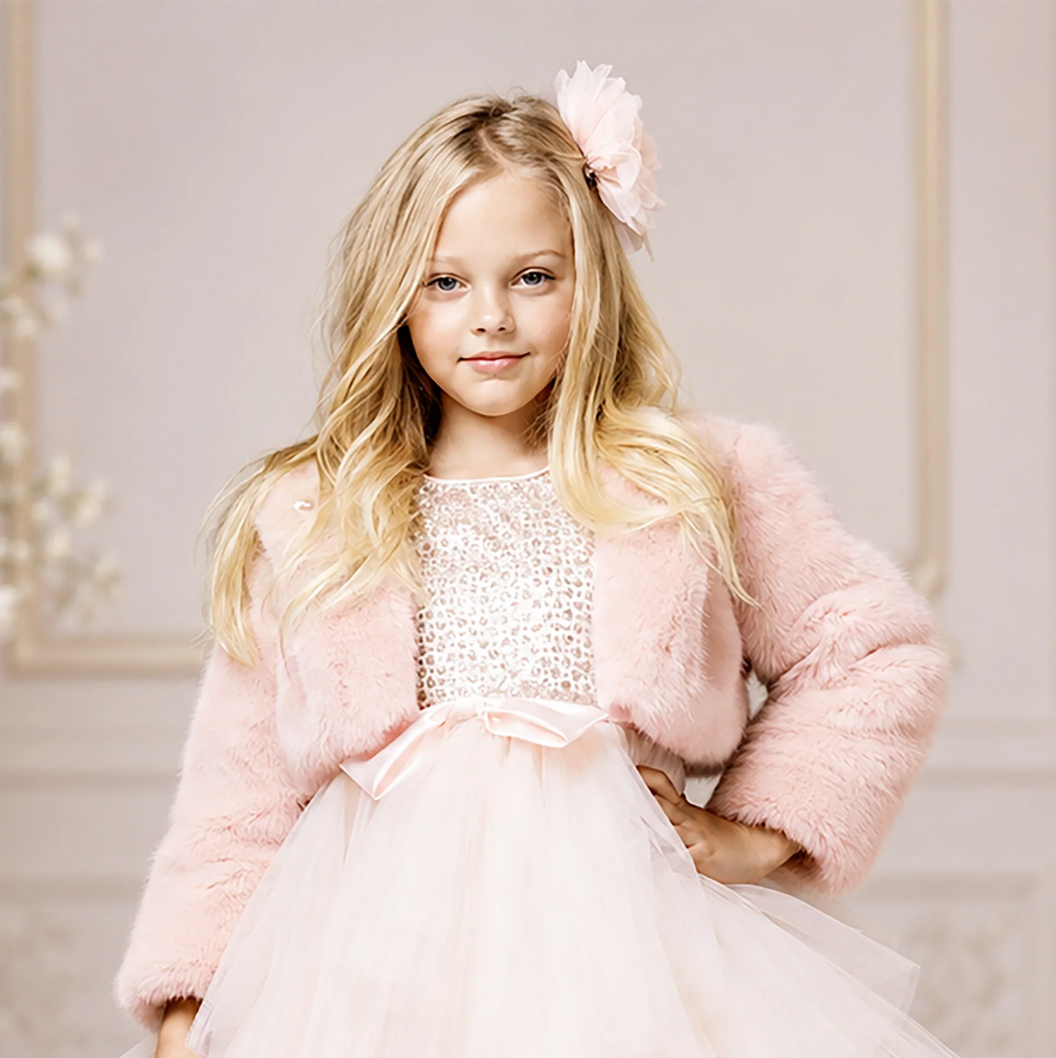 Girl wearing a blush faux fur bolero over a formal dress