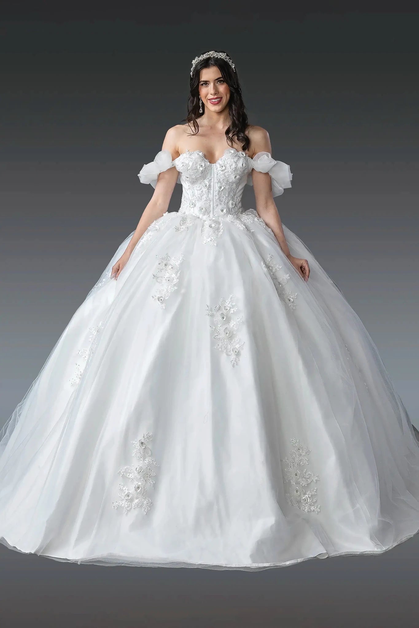 Woman in Off white puff sleeve ball gown dress with 3D florals and lace-up back.