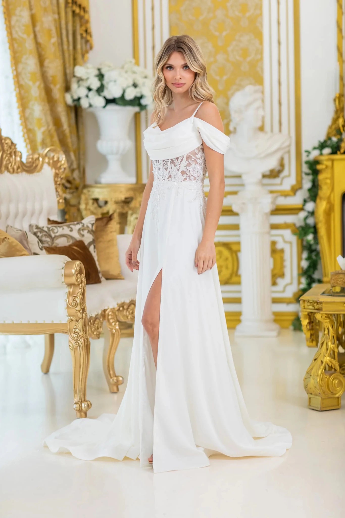 Woman in Off white off-shoulder wedding dress with sheer lace bodice and slit skirt.