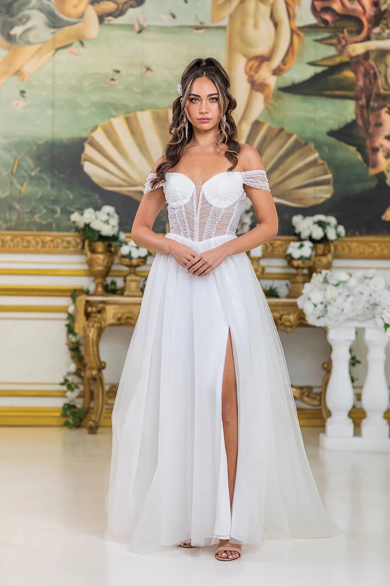 Woman in Off white off-shoulder wedding dress with sheer corset and slit.