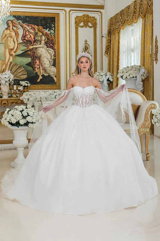 Woman in a white wedding dress standing in an ornate room with decorative elements.
