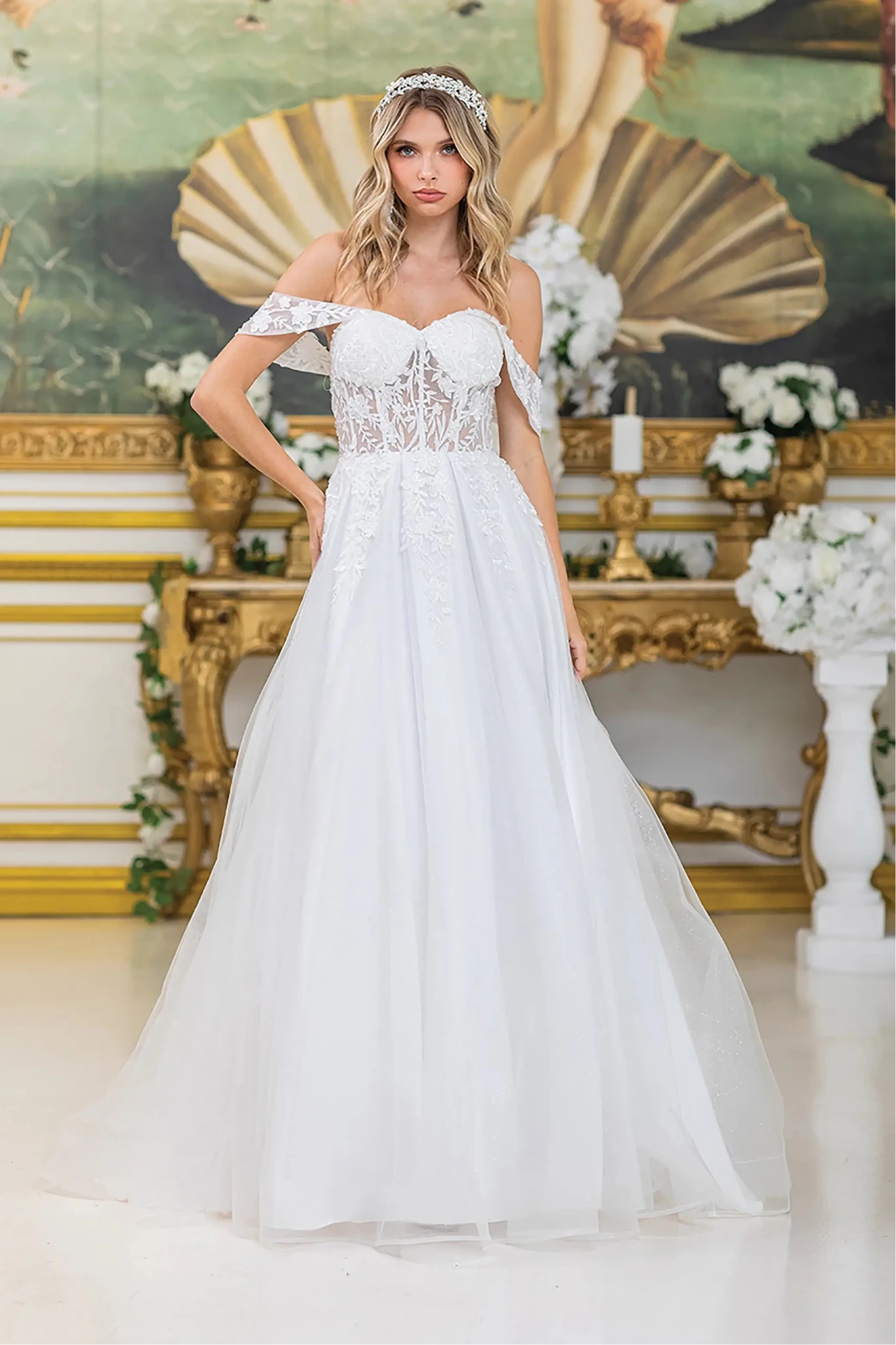 Woman in Off white off-shoulder A-line wedding dress with lace bodice and tulle skirt.