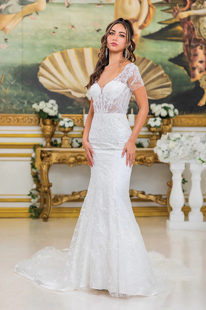Woman in Off white lace mermaid wedding dress with illusion bodice and train.