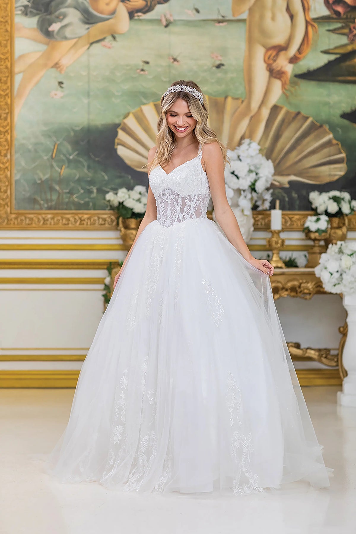 Showing a lace corset bodice above its full tulle skirt, this Off-White wedding dress is shown in full view.