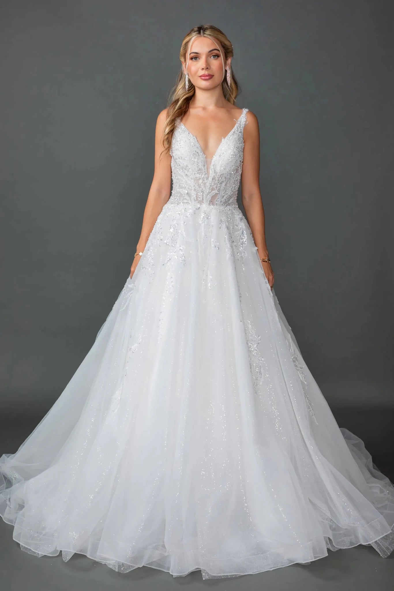 Woman in Off white wedding ball gown with sheer puff sleeves and glitter tulle skirt.