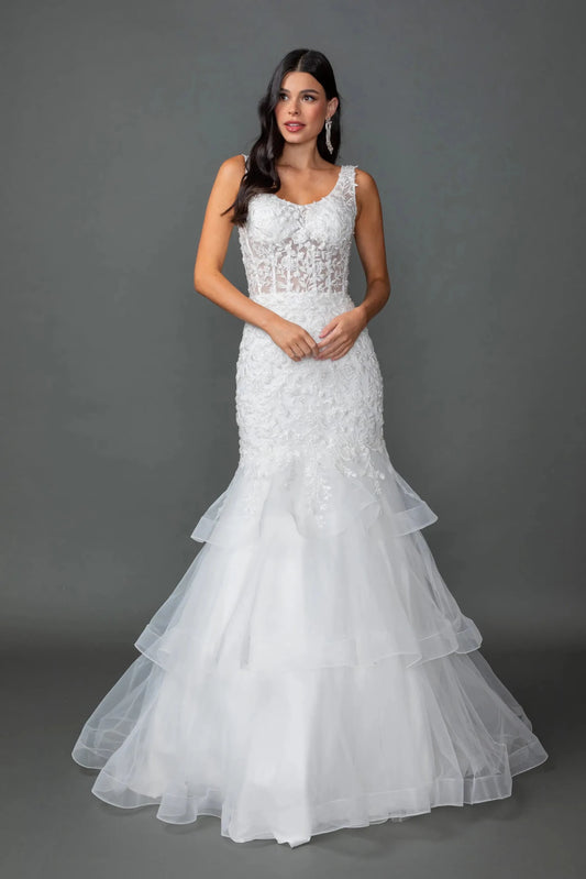 Woman in Off white sleeveless lace mermaid wedding gown with sheer bodice and tiered skirt.