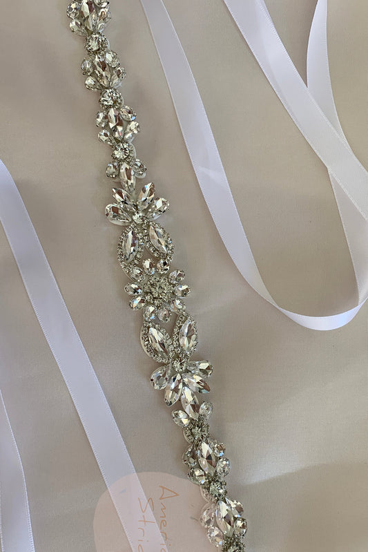 Silver rhinestone floral flower girl sash belt, close-up, embellishment detail.