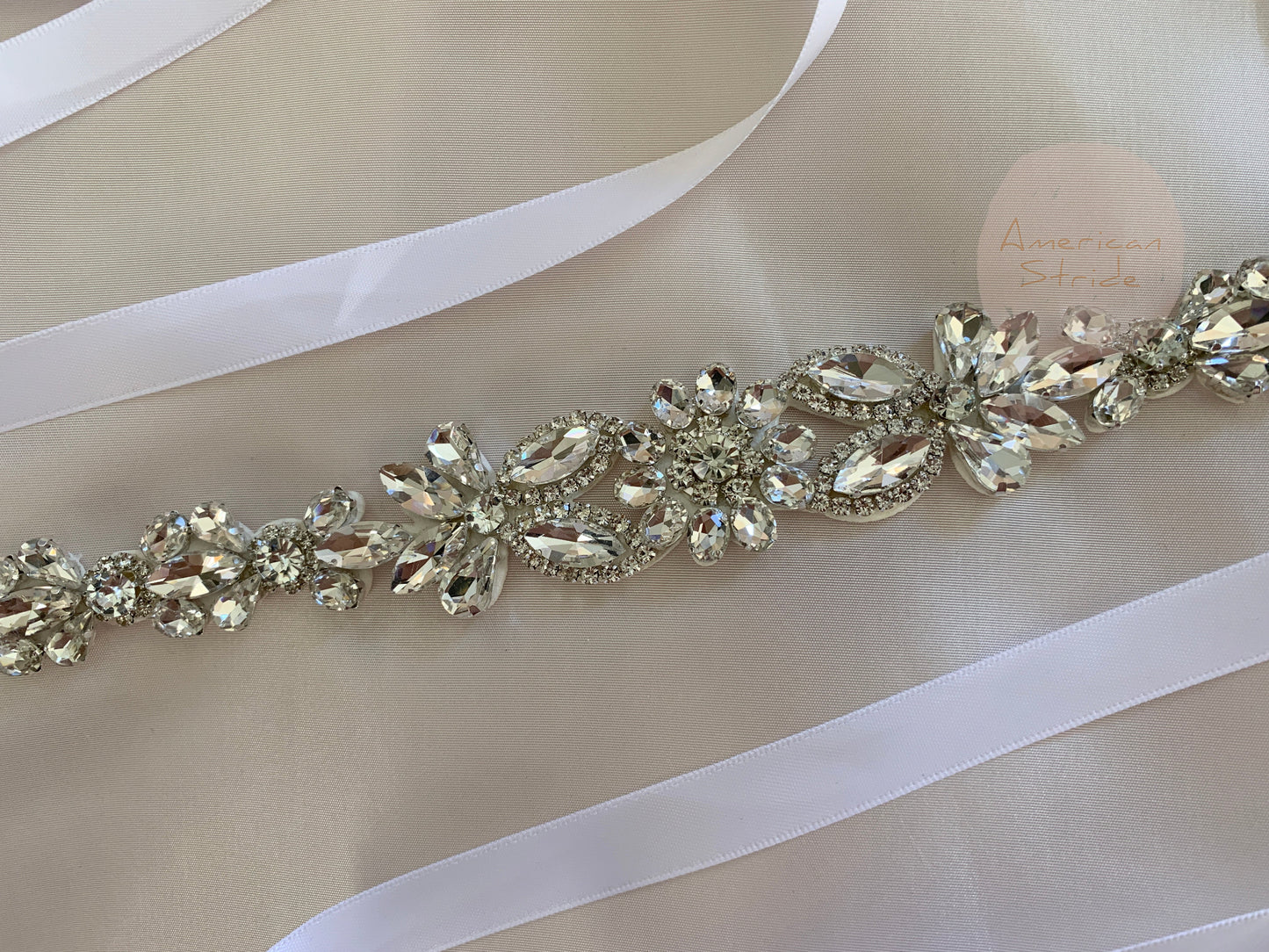 Silver rhinestone floral flower girl sash belt, close-up, embellishment detail.