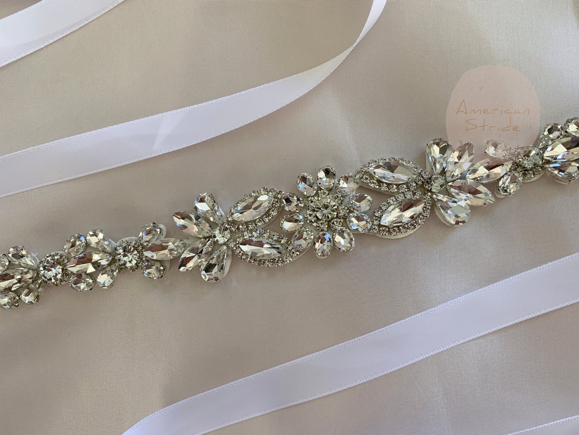 Silver rhinestone floral flower girl sash belt, close-up, embellishment detail.