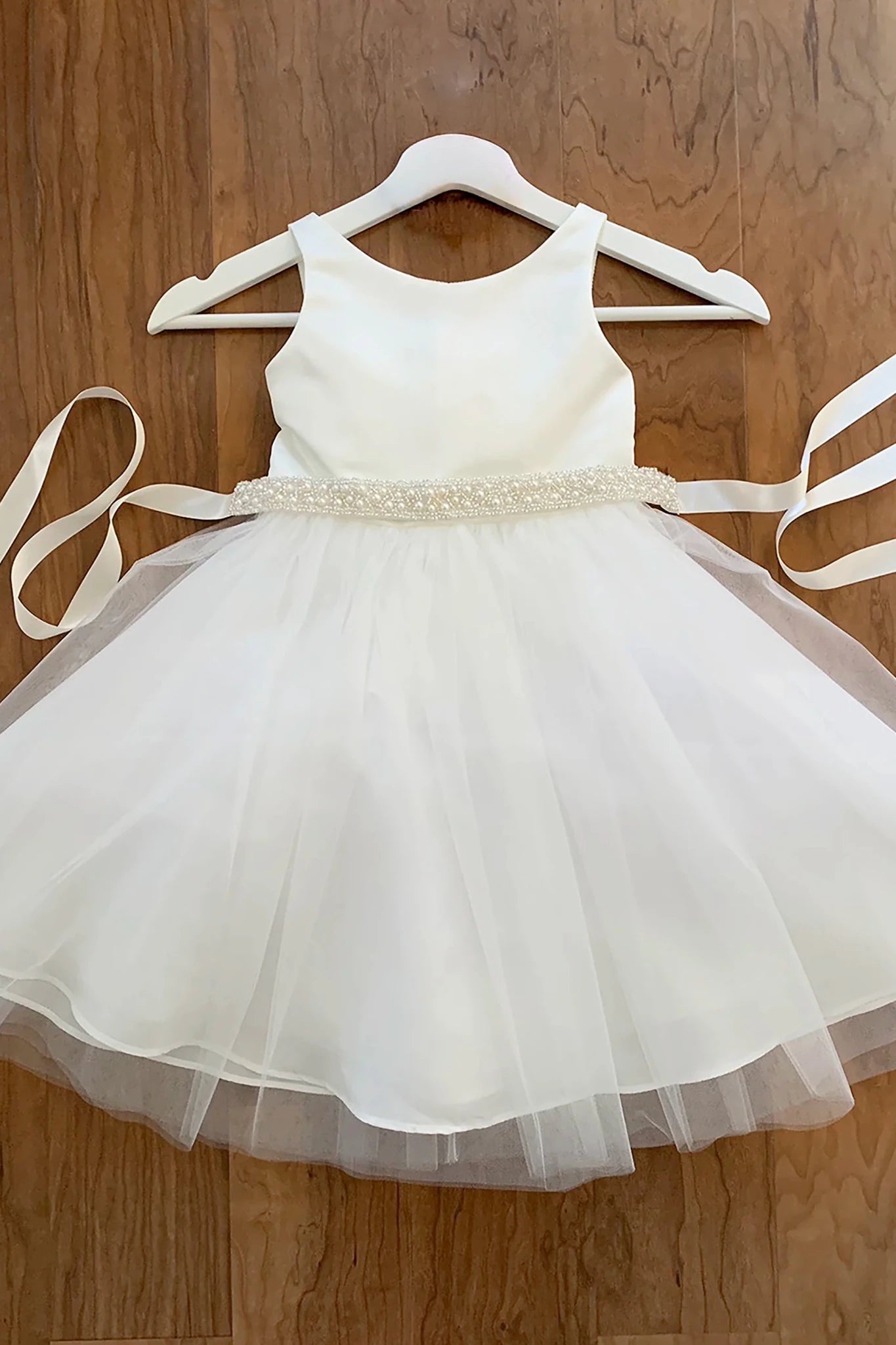 Off white sleeveless flower girl dress with a ivory pearl sash 