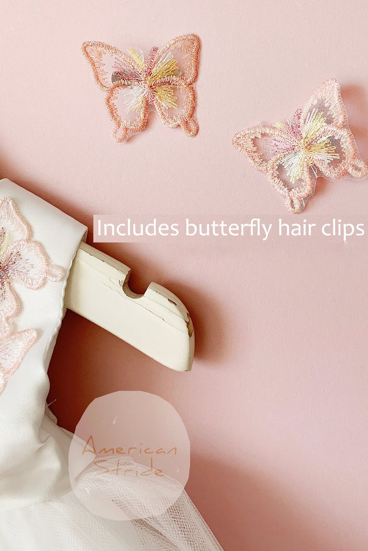 White four-layer tulle flower girl dress with butterfly details and a full skirt.