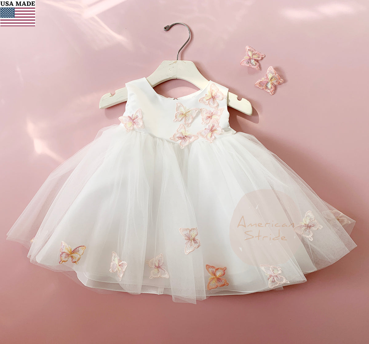 White children's flower girl dress with butterfly designs.