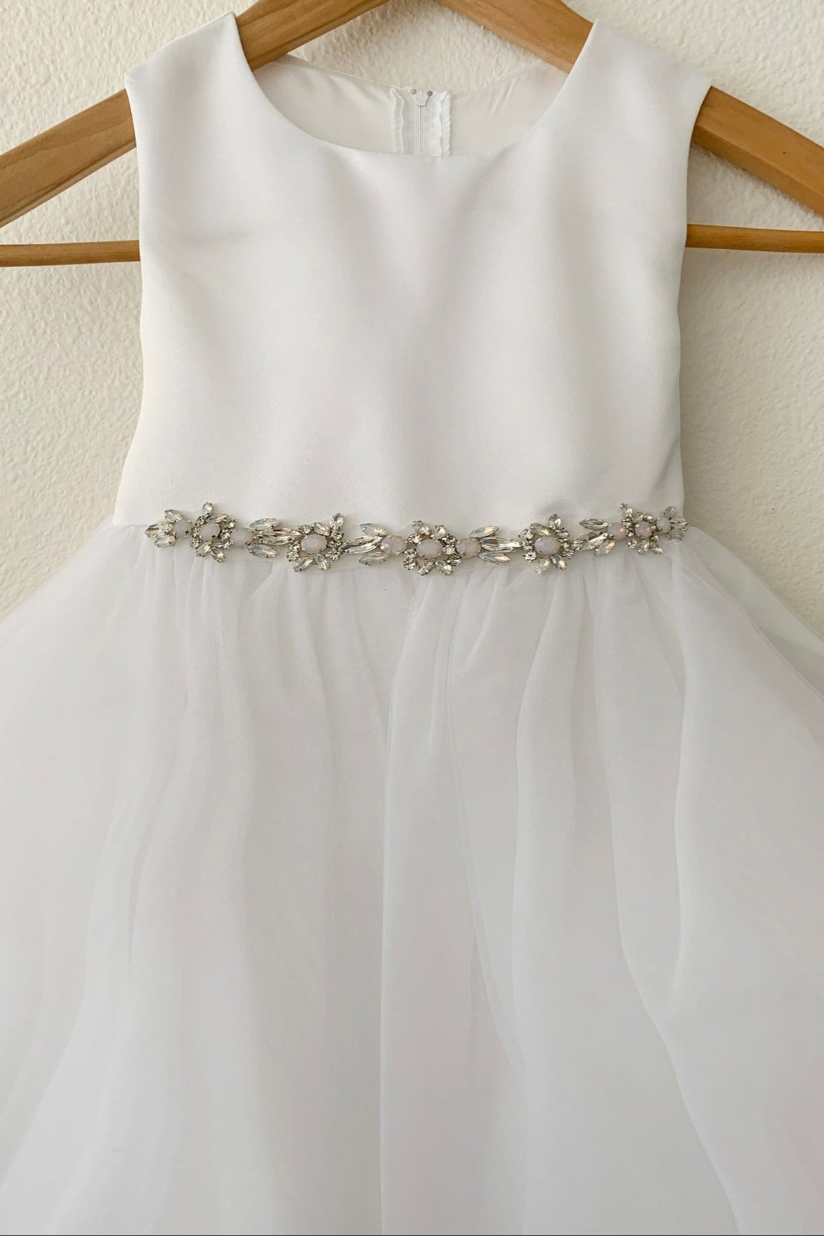 White flower girl dress with a decorative rhinestone belt.