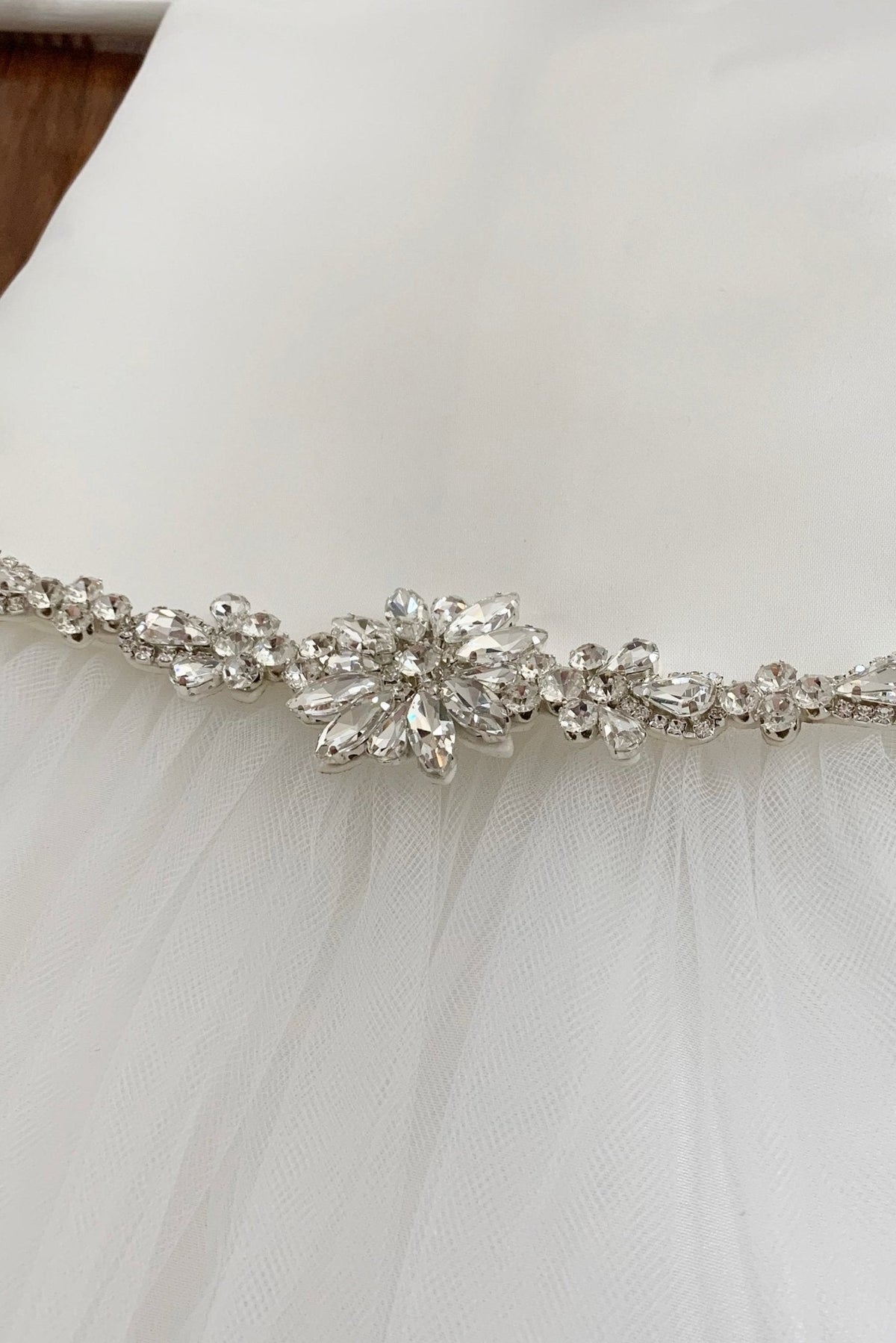 White tulle satin flower girl dress with a decorative silver belt.
