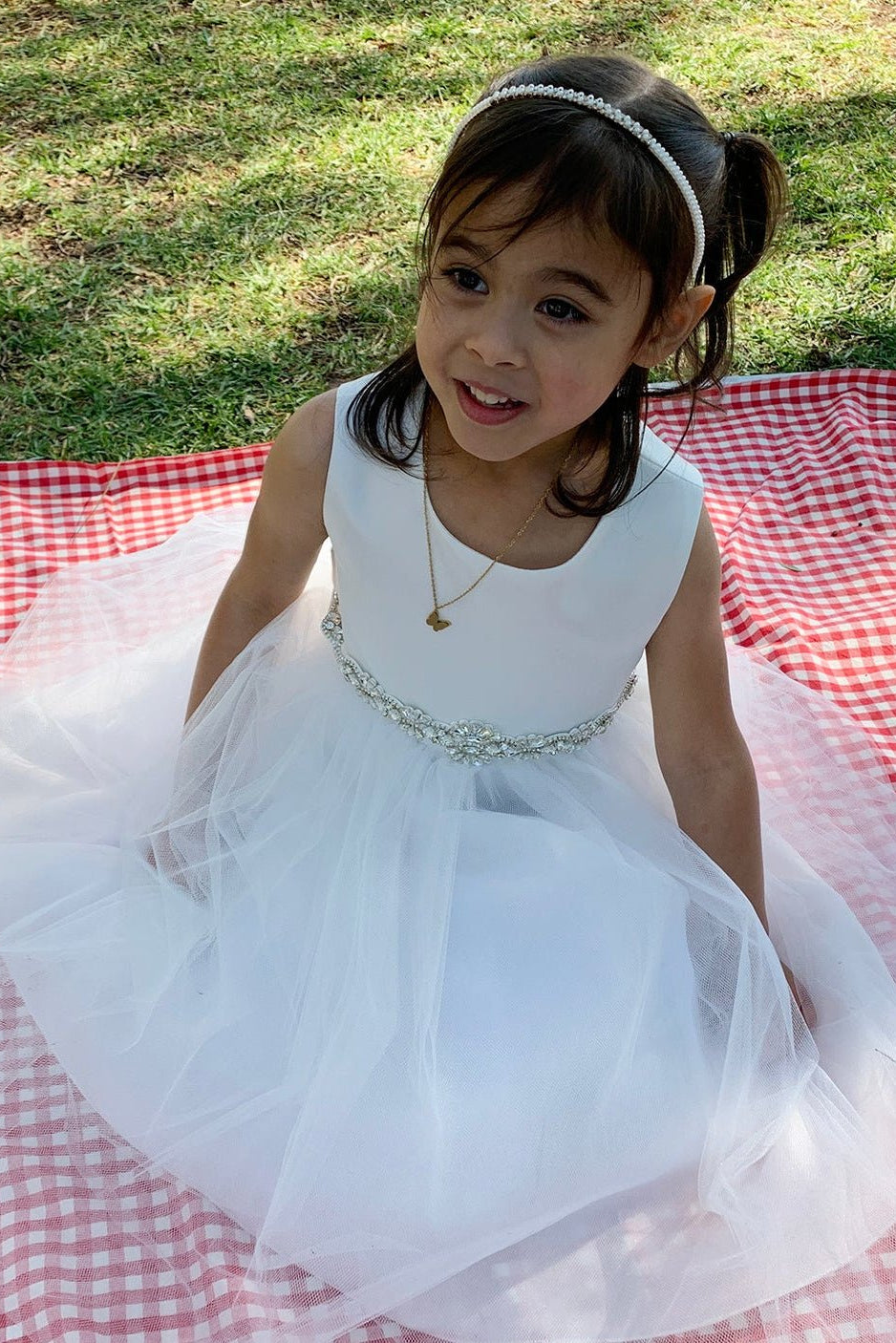 A white tulle flower girl dress with rhinestone belt.