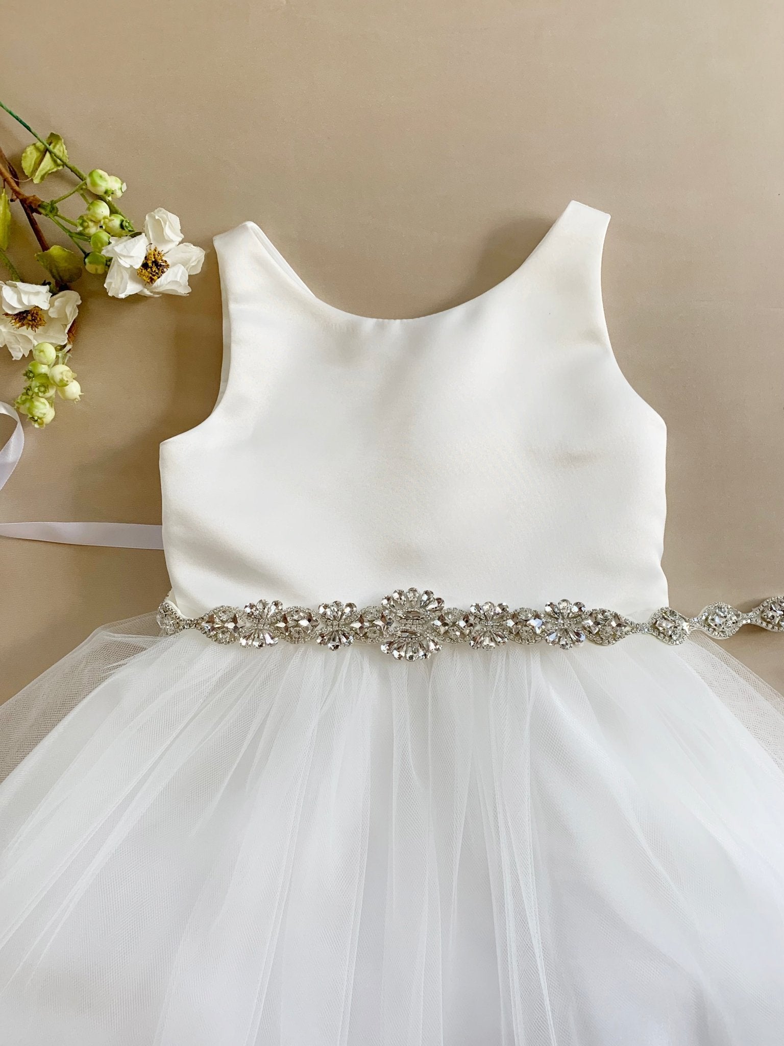 White satin and tulle flower girl dress with a decorative crystal belt.