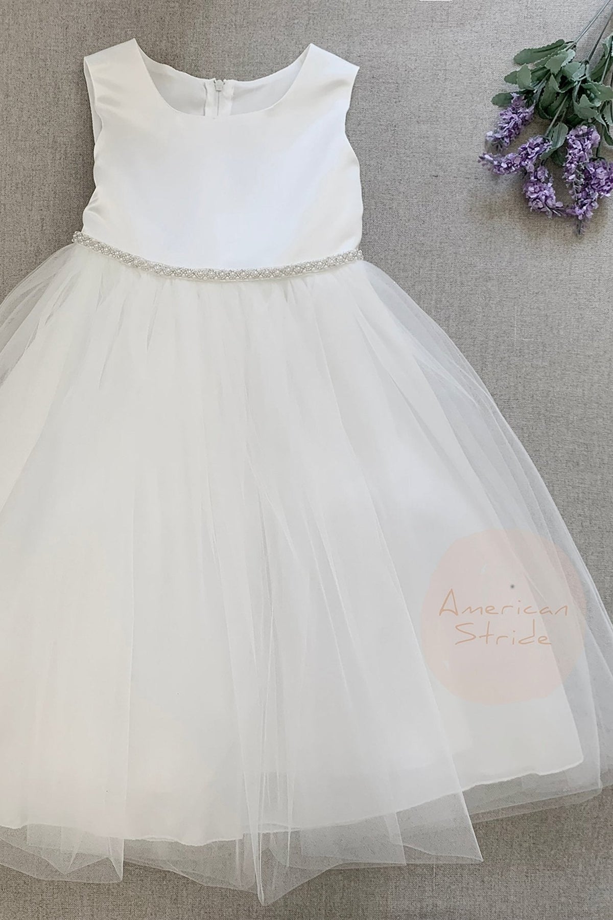 White flower girl dress with a sheer skirt.