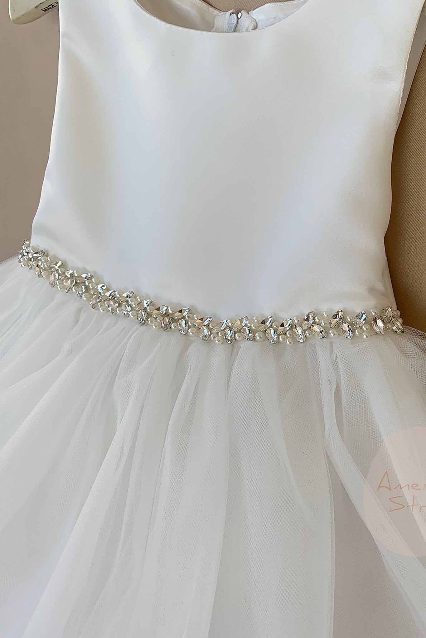 White flower girl dress with a decorative rhinestone pearl belt.