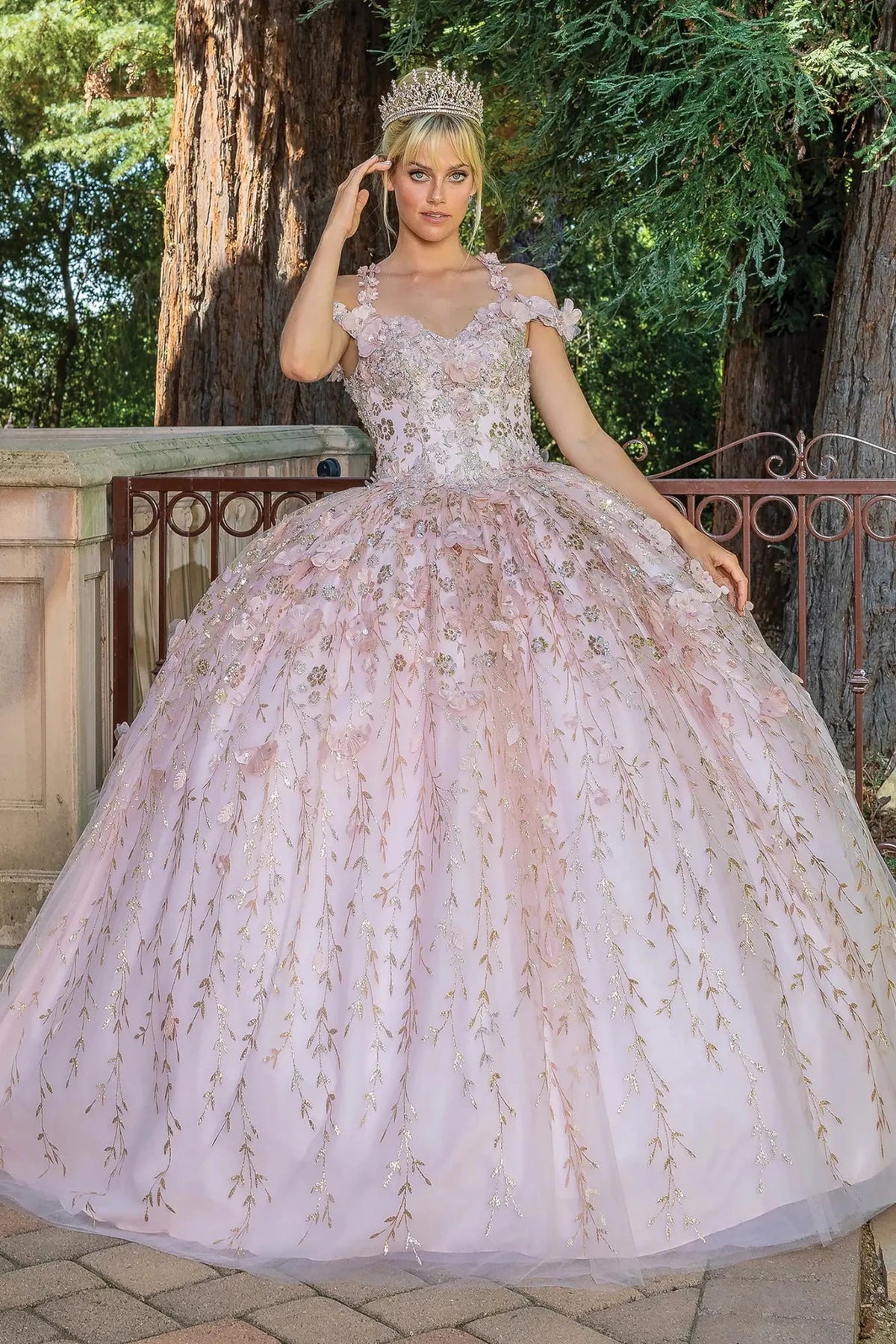 Front view of a Blush quinceañera gown with off-the-shoulder neckline, floral appliqués, and embroidered tulle skirt