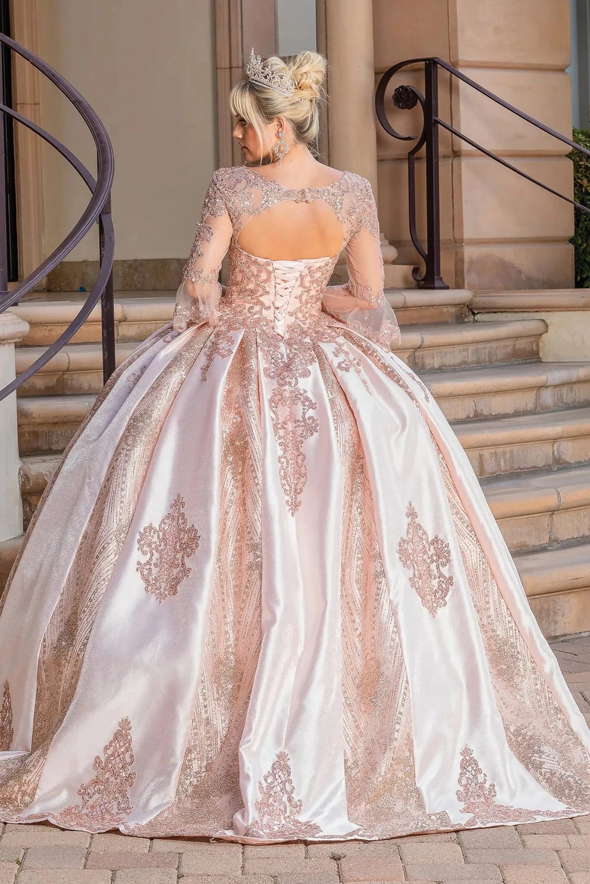 Back view of a Rose Gold quinceañera gown showing lace-up back, glitter tulle skirt, and embroidered lace