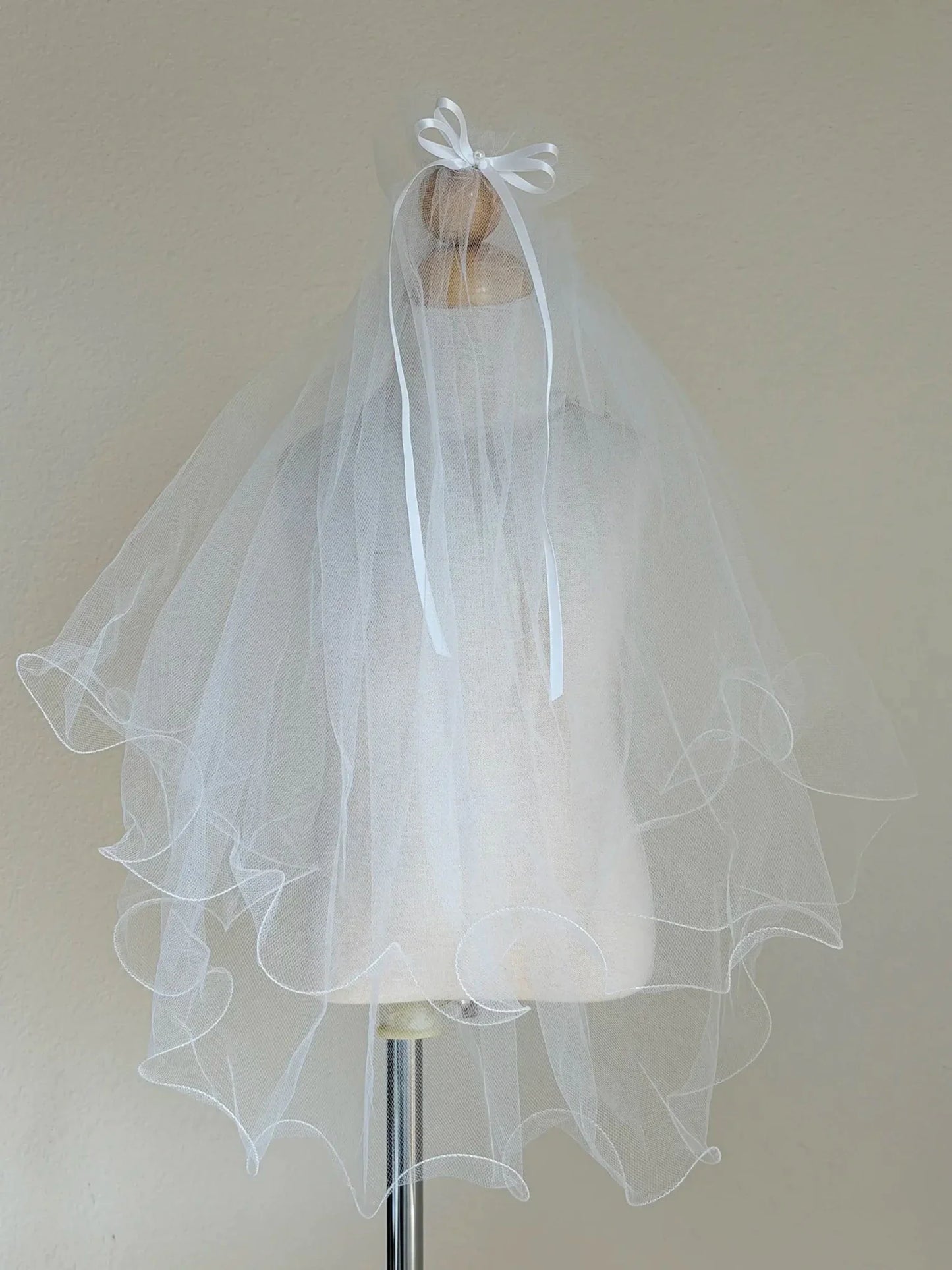 White rhinestone cross first communion tiara and two-tier veil.
