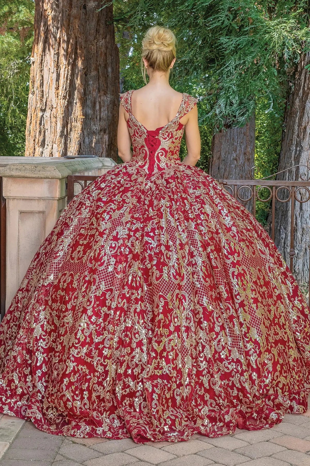 Back view of a Burgundy quinceañera gown showing lace-up back and scalloped hemline