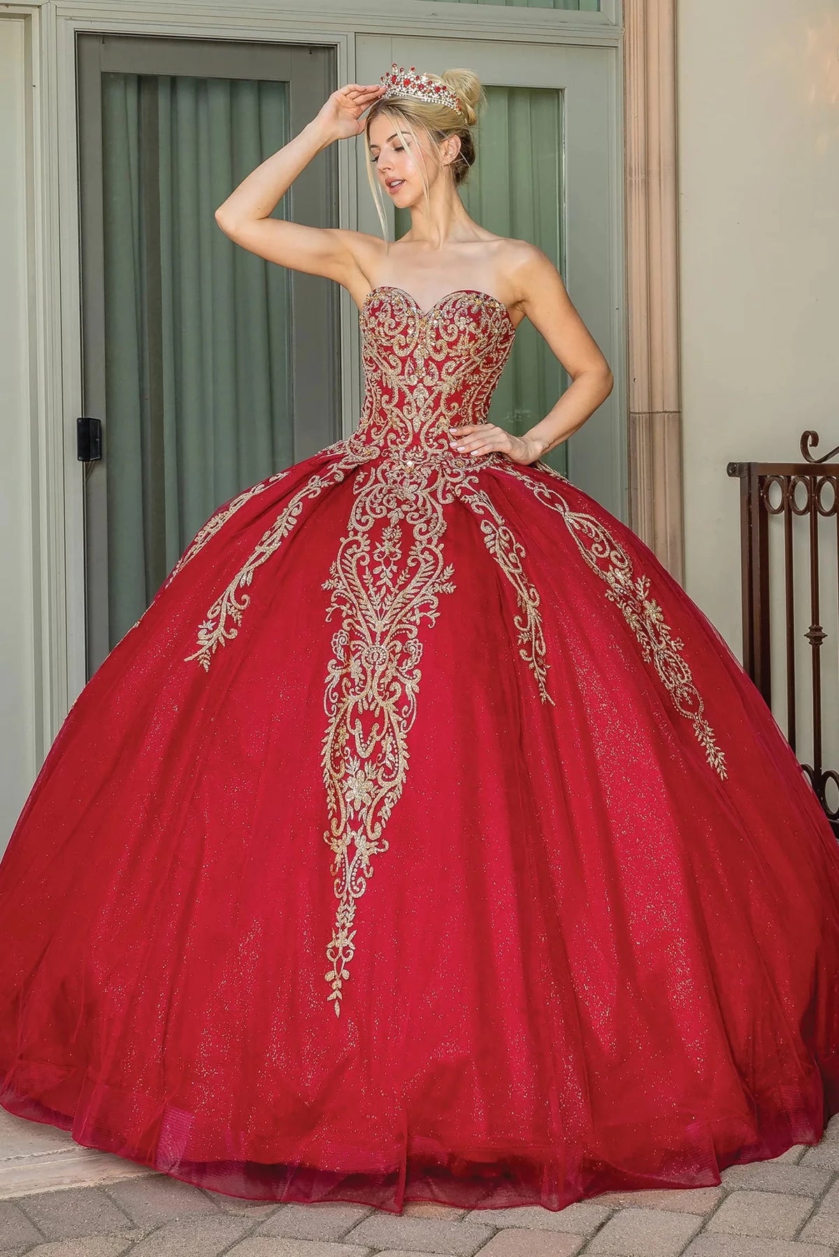 Front view of a Burgundy quinceañera gown with strapless neckline, beaded bodice, and full tulle skirt