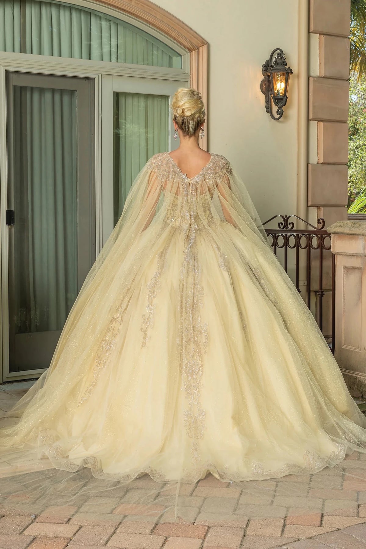 Back view of a Champagne quinceañera gown showing lace-up back and full tulle skirt
