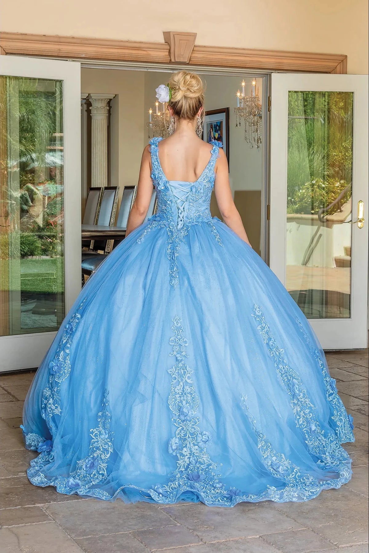 Back view of a Bahama Blue quinceañera gown showing lace-up back, voluminous full skirt, and embroidered lace