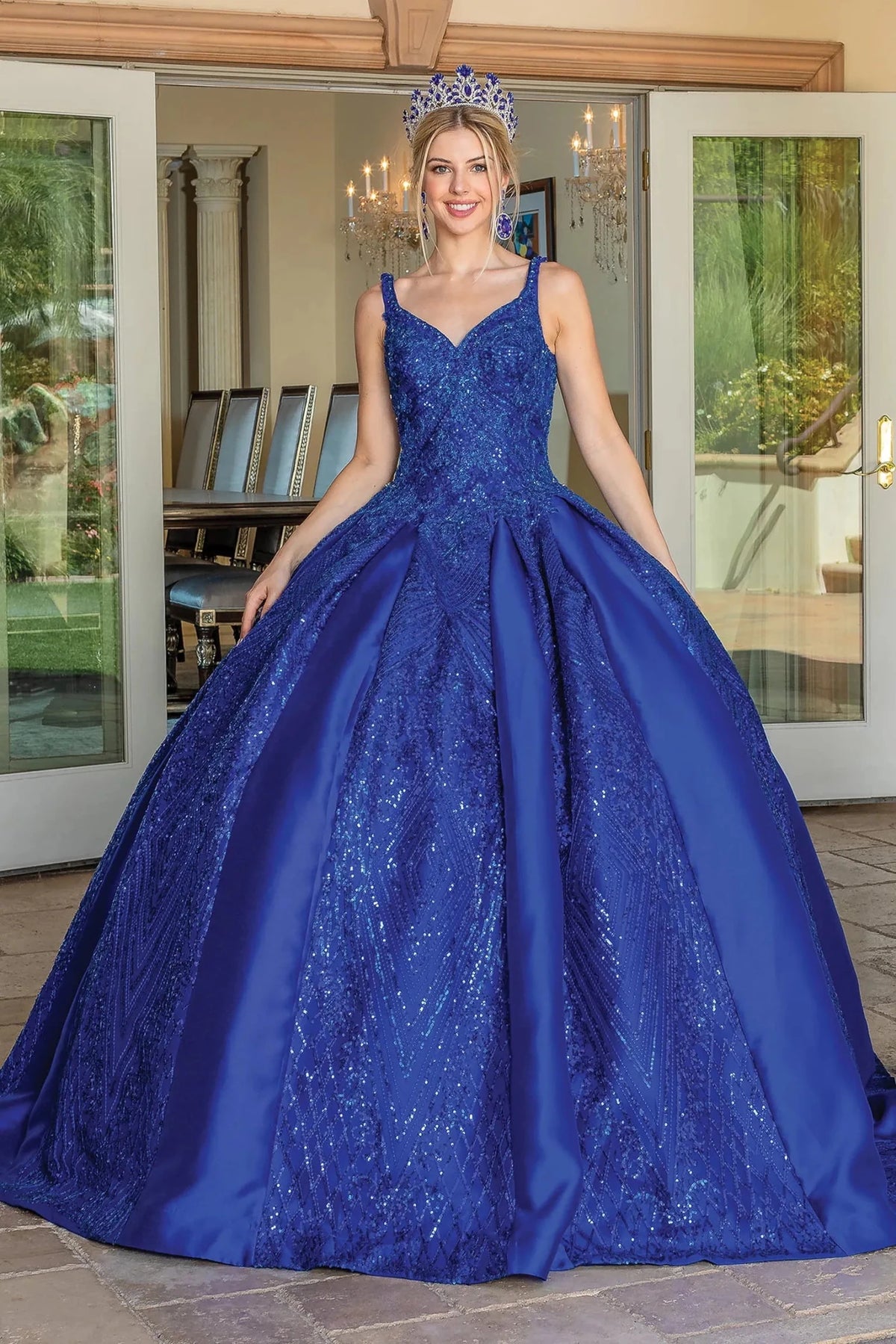 Front view of a Royal Blue quinceañera gown with V-neckline, beaded bodice, lace appliqués, and voluminous full skirt