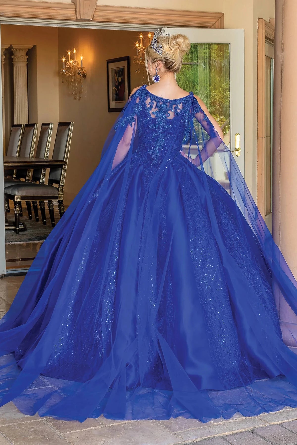 Back view of a Royal Blue quinceañera gown showing lace-up back, voluminous full skirt, and lace appliqués