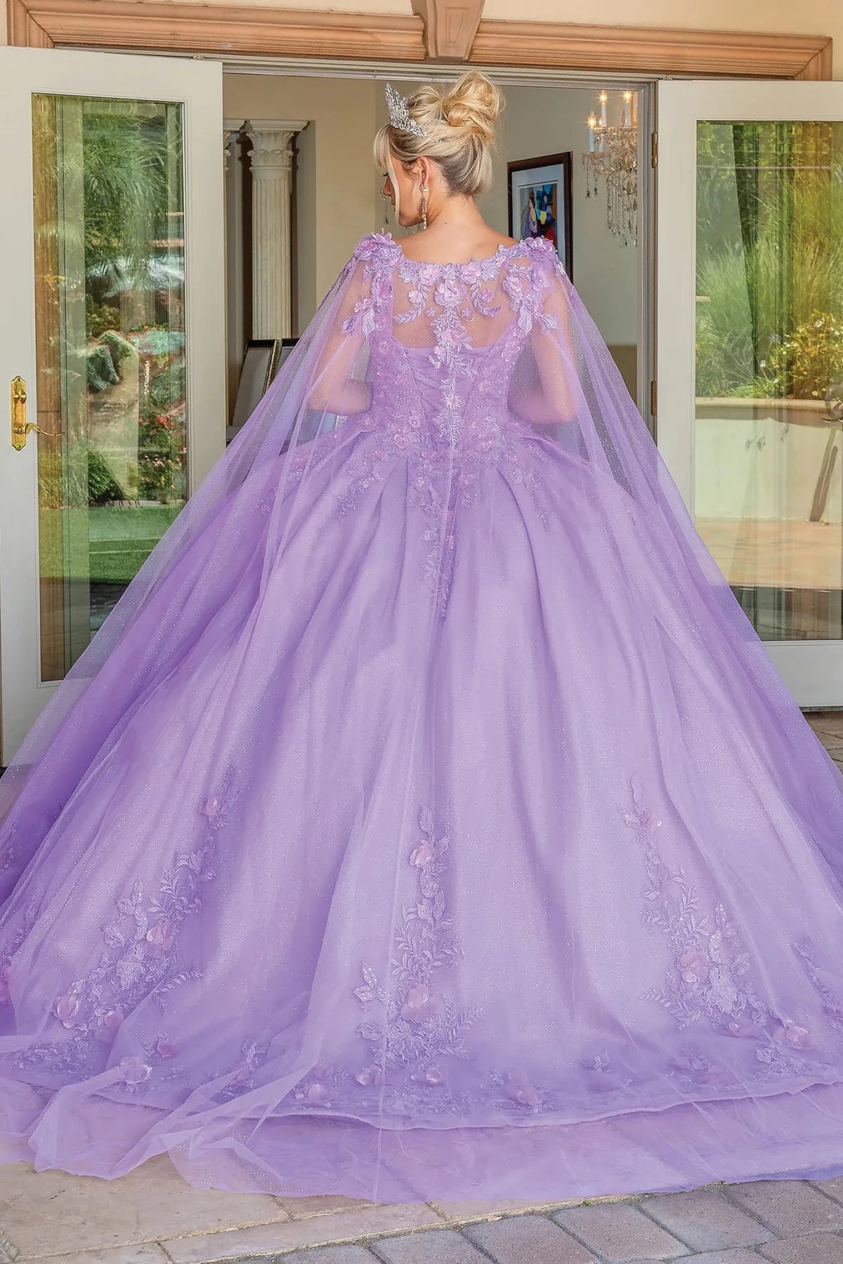 Back view of a Lilac quinceañera gown showing lace-up back, sheer sleeves, and lace appliqués