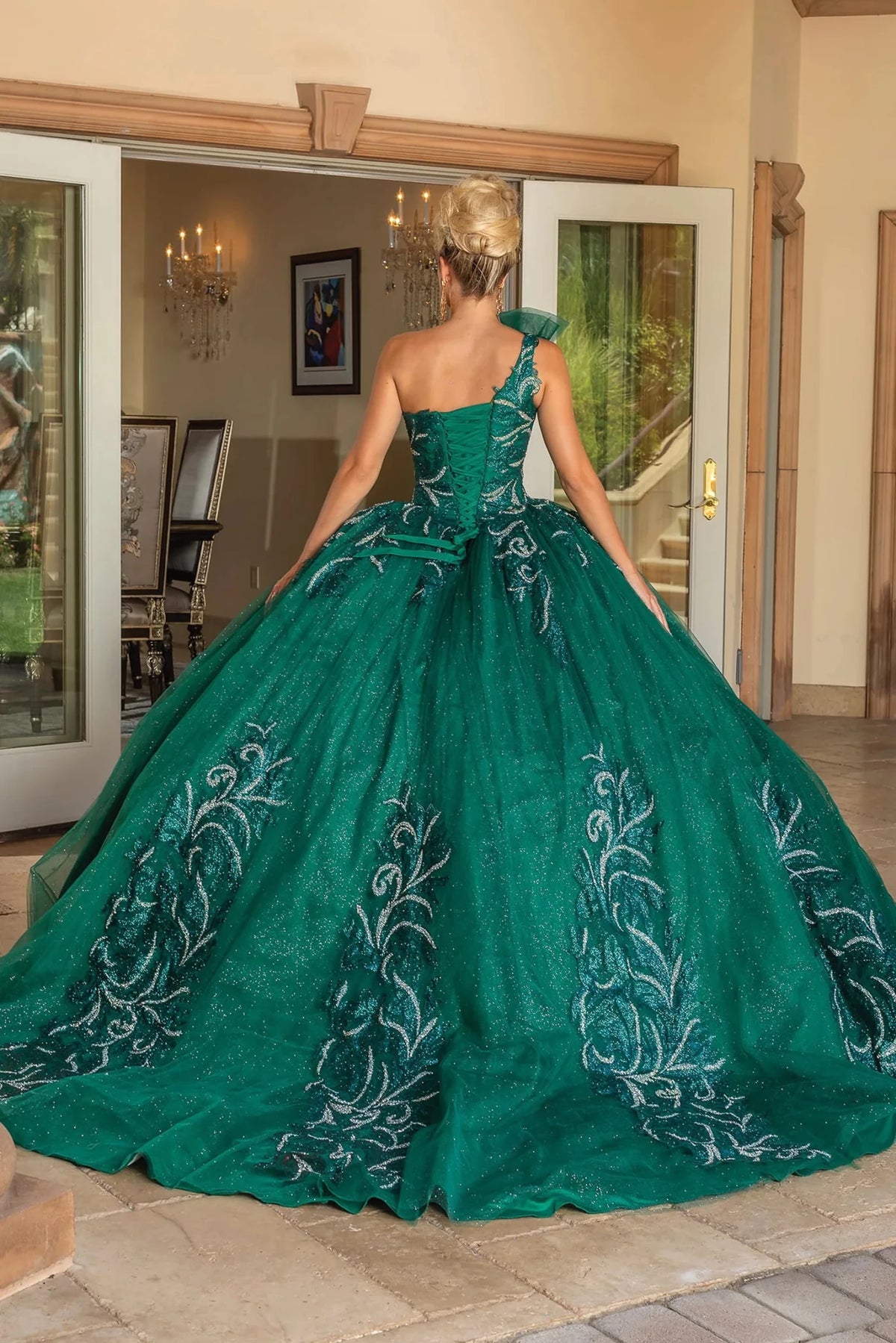 Back view of a Hunter Green quinceañera gown showing lace-up back and flowing train