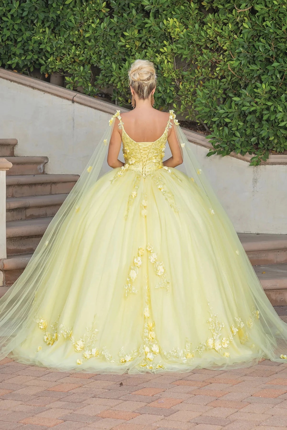 Back view of a Yellow quinceañera gown showing lace-up back, cap sleeves, and floral appliqués