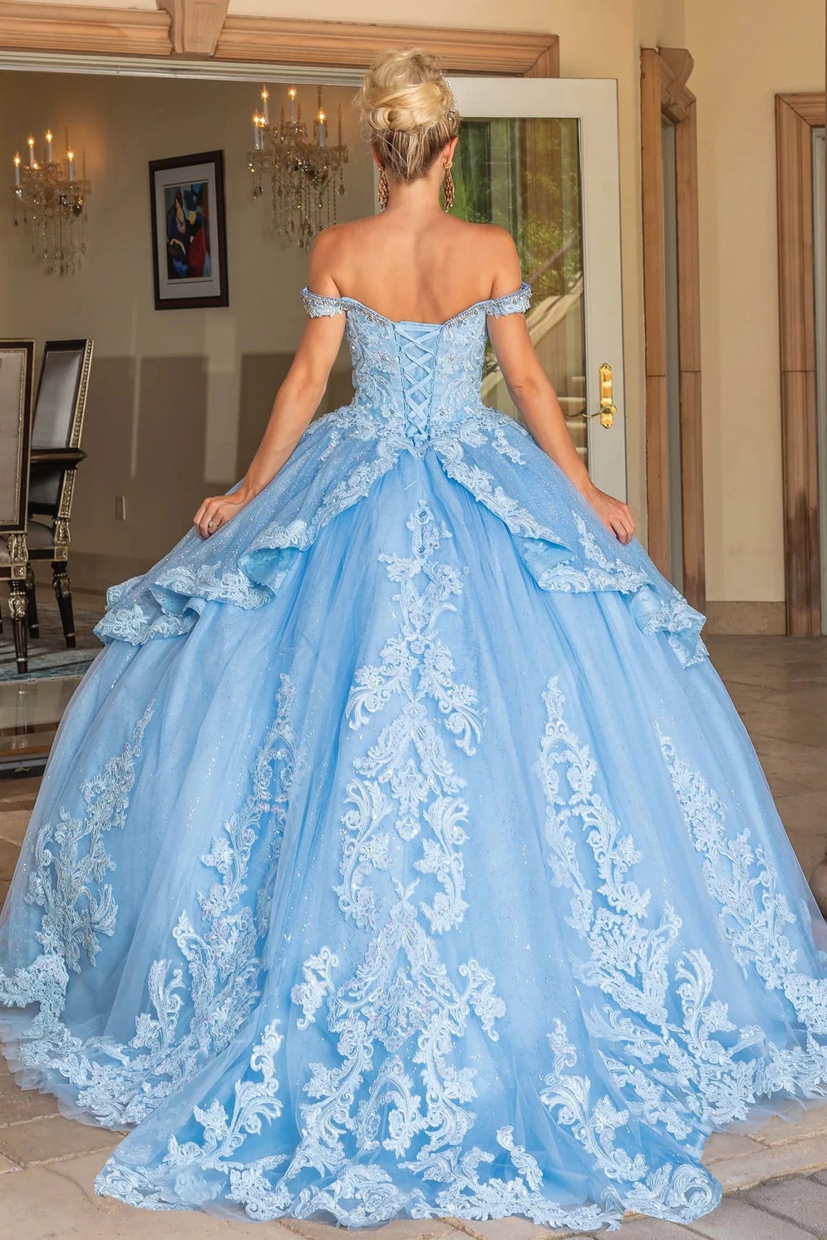 Back view of a Bahama Blue quinceañera gown showing lace-up back and embroidered tulle skirt