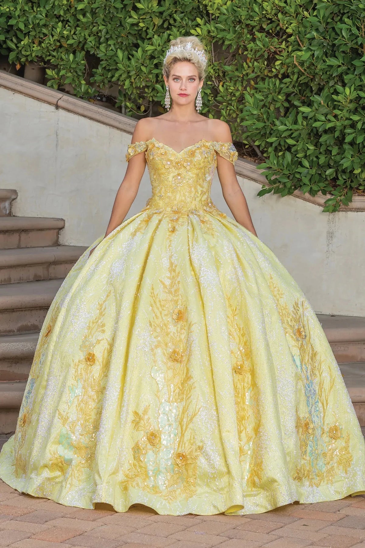 Front view of a Yellow quinceañera gown with off-the-shoulder neckline, floral appliqués, and glitter tulle skirt