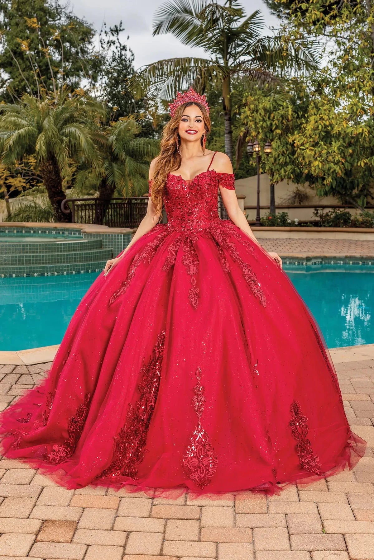Front view of a Burgundy quinceañera gown with off-the-shoulder neckline, corset bodice, lace appliqués, and voluminous full skirt