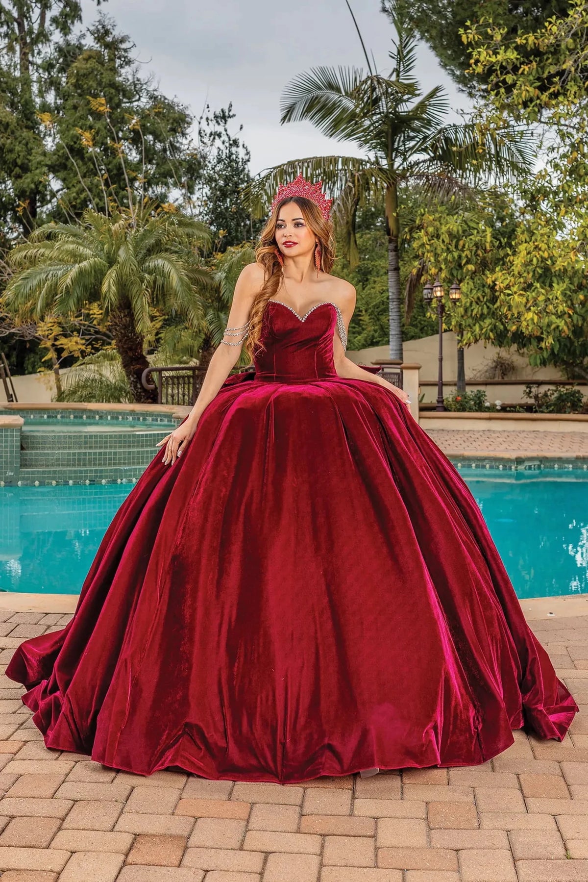 Front view of a Burgundy quinceañera gown with off-the-shoulder neckline and crystal accents