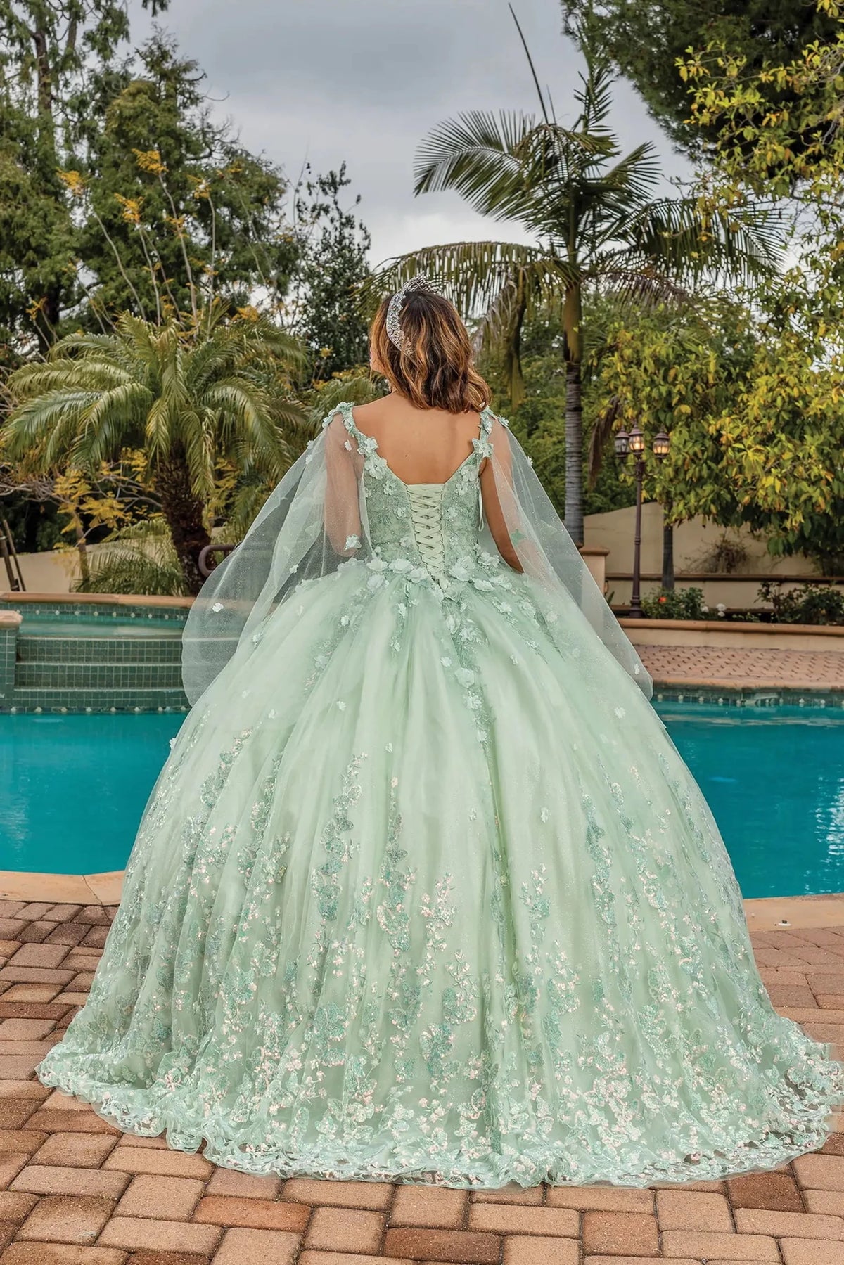 Back view of a Sage quinceañera gown showing lace-up back and floral embroidery