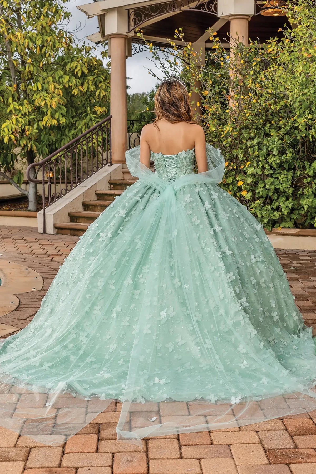 Rear view of a Sage quinceañera gown showing lace-up back and floral appliqués