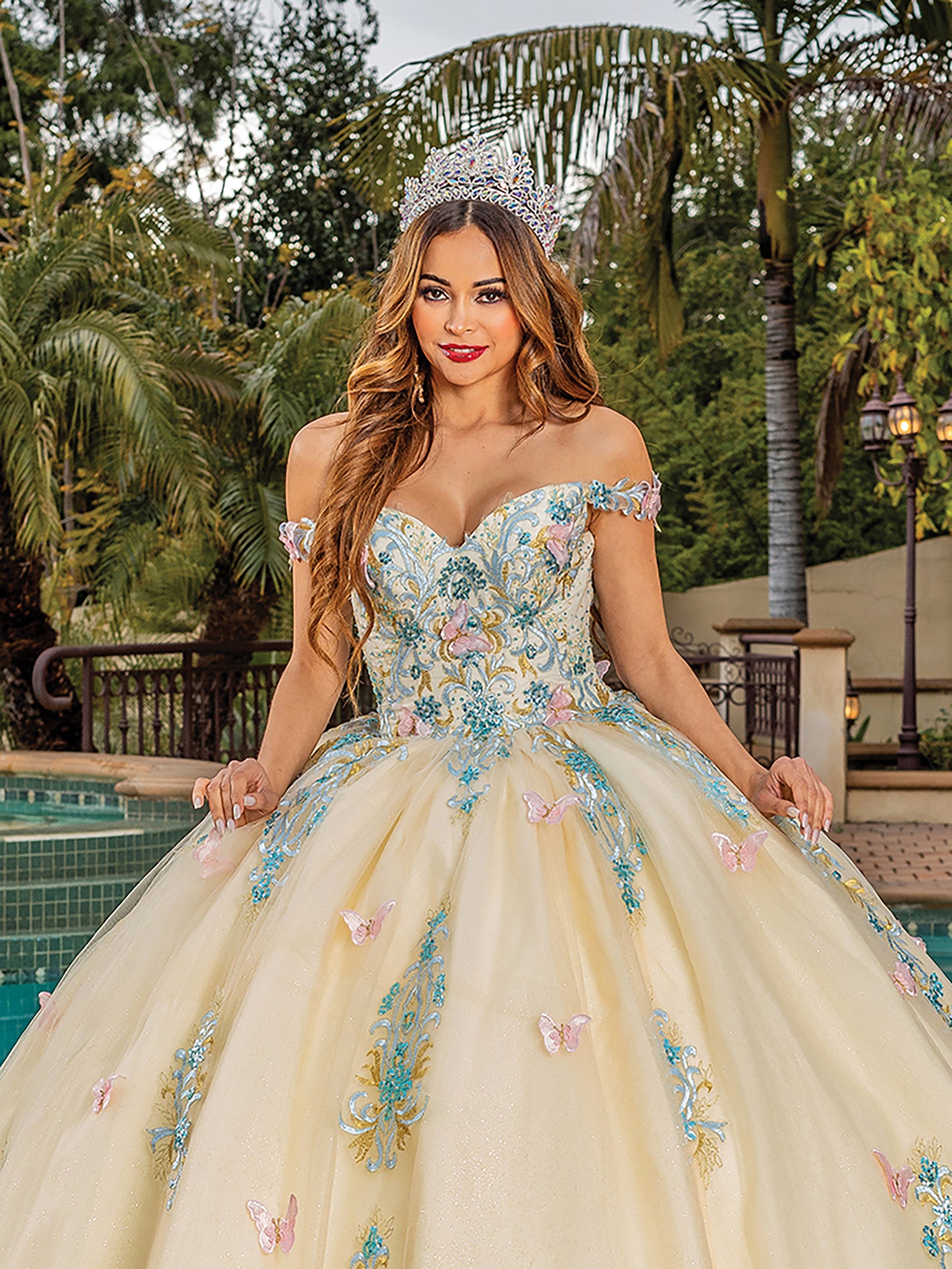 Quinceanera | Off-the-Shoulder Crystal Embellished Lace Appliqués, Beaded Butterflies, and Tulle Skirt Quinceanera dress - zoomed in view of woman wearing dress - front