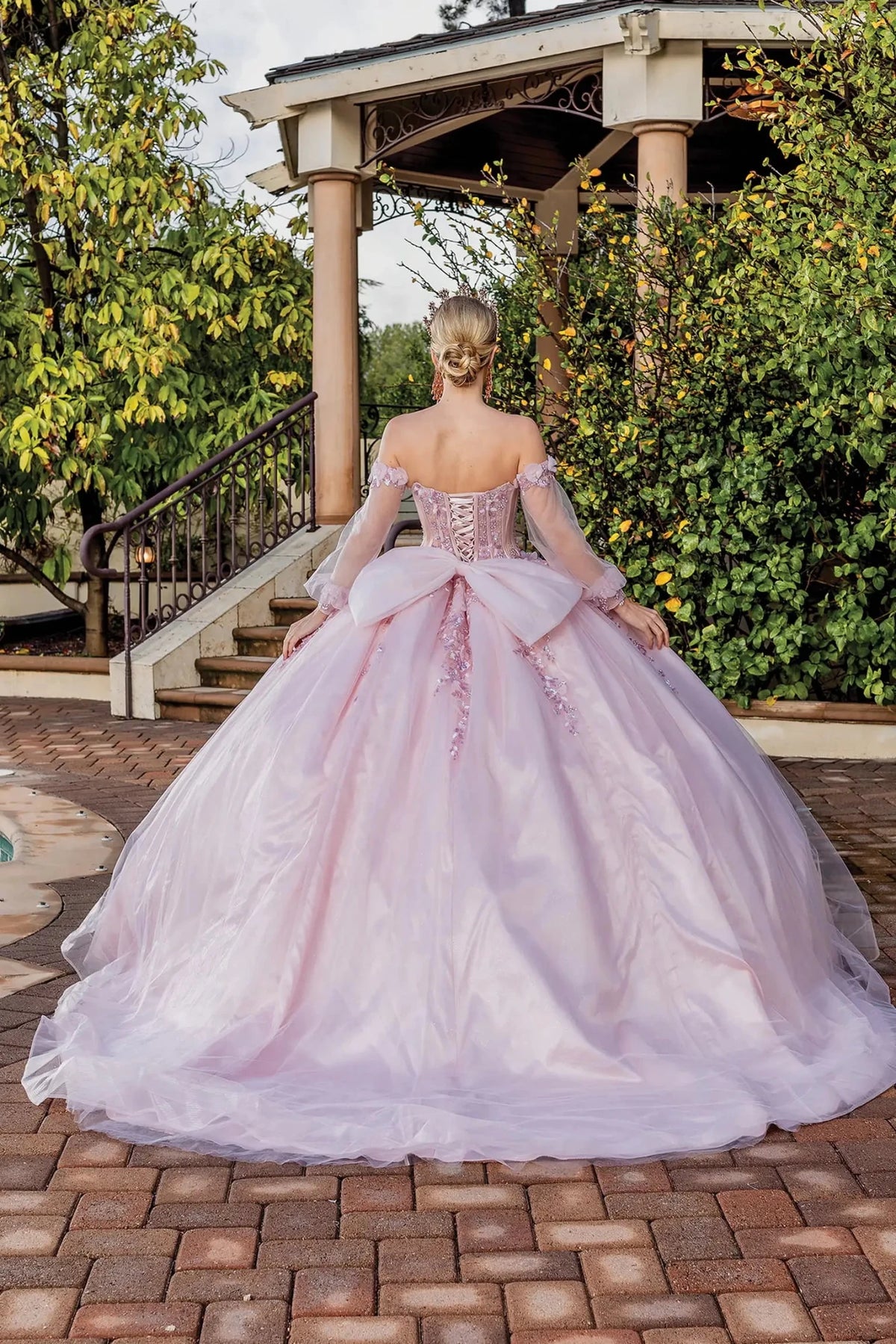Back view of a Blush quinceañera gown showing lace-up back and floral appliqués