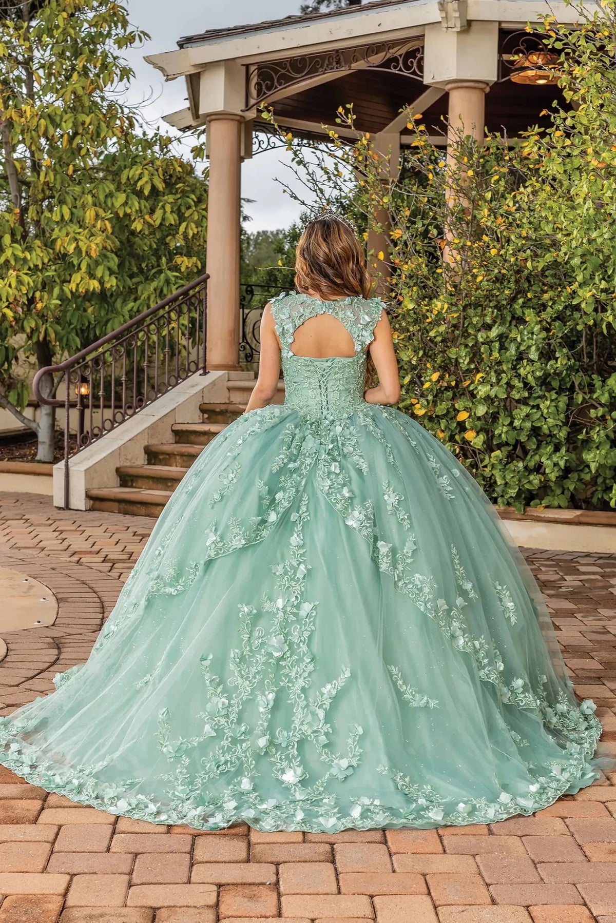 Back view of a Sage quinceañera gown showing lace-up back and floral appliqués