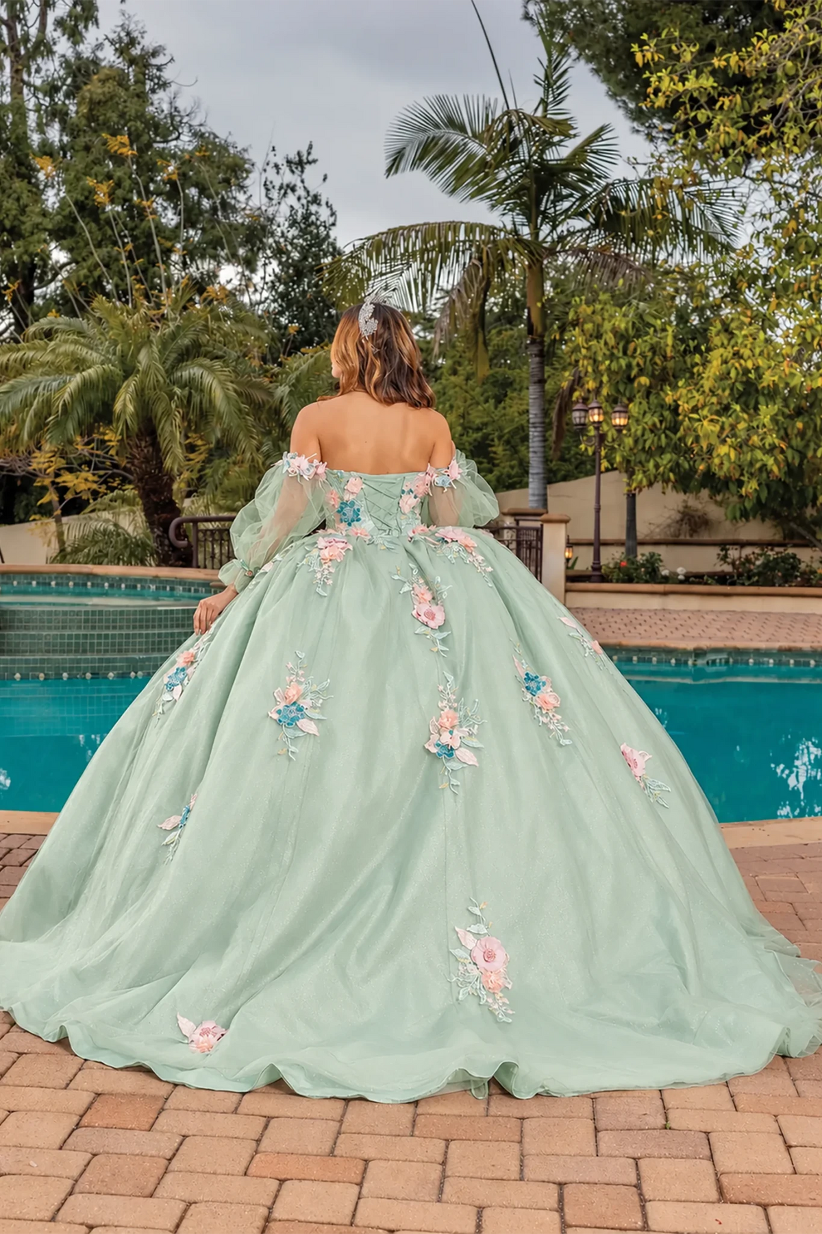 green ball gown with pink and blue floral embroidery and lace up back 