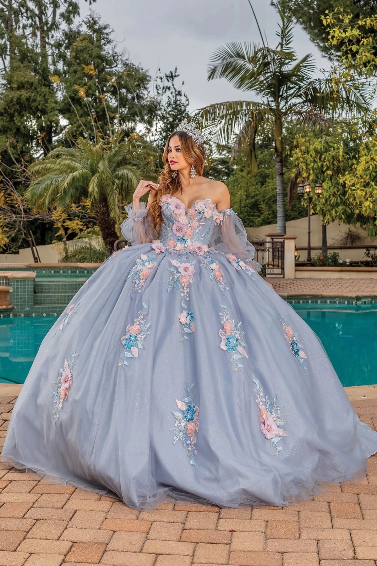 Front view of a Silver quinceañera gown with sheer sleeves, floral appliqués, and voluminous full skirt
