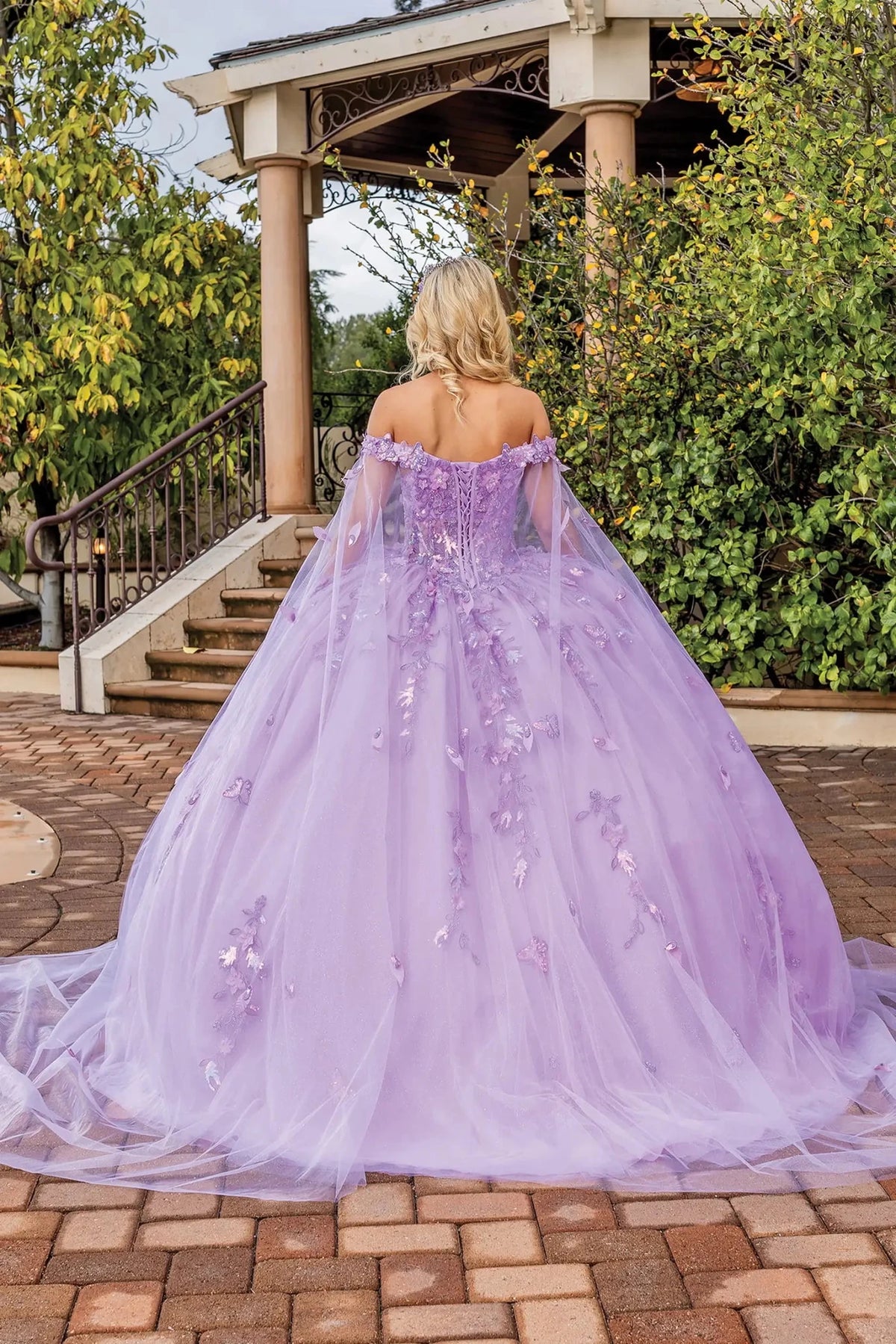 Back view of a Lilac quinceañera gown showing lace-up back, detachable sleeves, and floral appliqués