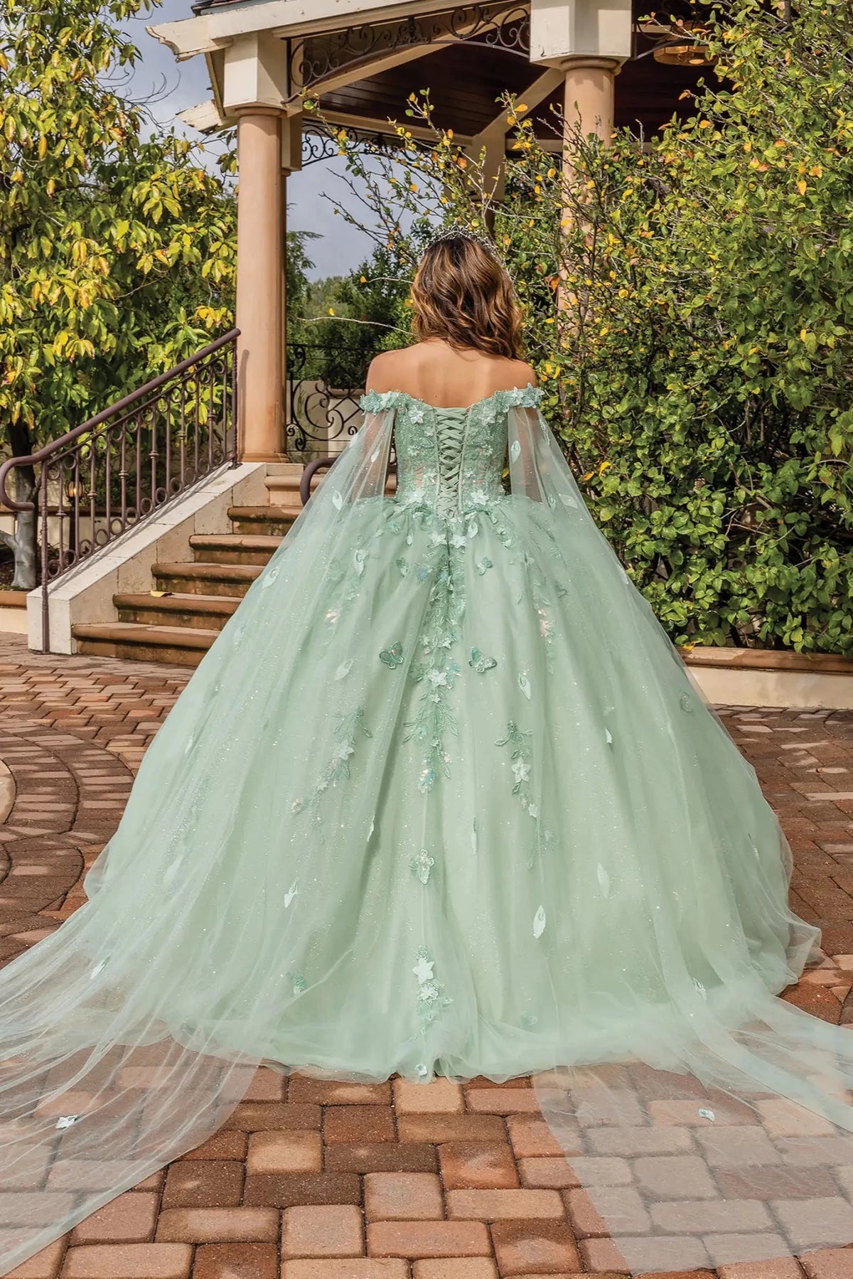 Back view of a Sage quinceañera gown showing lace-up back, detachable sleeves, and floral appliqués