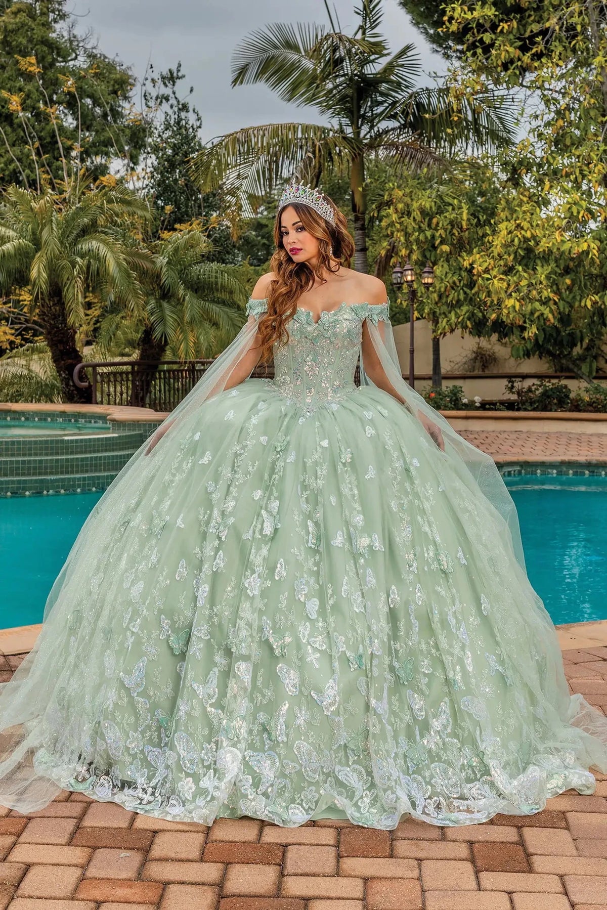 Full-length front view of a Sage quinceañera gown with off-the-shoulder neckline and floral appliqués