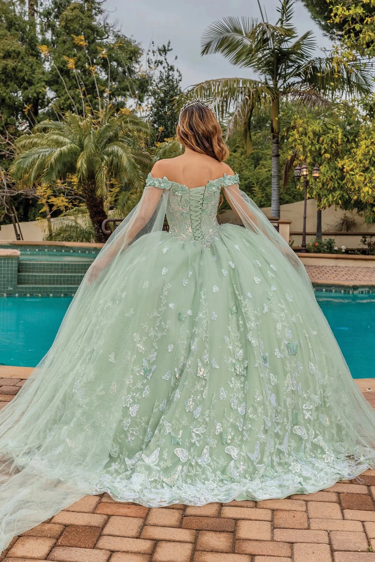Full-length back view of a Sage quinceañera gown showing lace-up back and floral appliqués